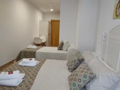 a hotel room with two beds and a couch at Lar do Peregrino in Palas de Rei