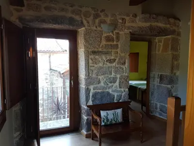 a room with a door and a stone wall at CAPELA DA GRANXA in Pontevedra