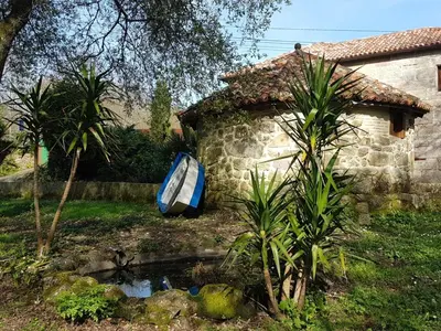a blue boat sitting in a yard next to a house at CAPELA DA GRANXA in Pontevedra