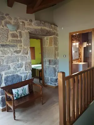 a room with a staircase and a stone wall with a bench at CAPELA DA GRANXA in Pontevedra