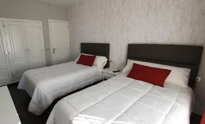 two beds sitting next to each other in a bedroom at Hotel Prados in Lugo