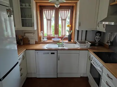 a kitchen with white cabinets and a sink and a window at Casa Camino Santiago-Fisterra in Amés