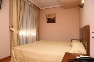 a small bedroom with a bed and a window at Hotel Restaurante Casa Pipo in Tuña