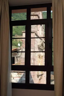 a window with a view of the ruins seen through it at Hotel Restaurante Casa Pipo in Tuña