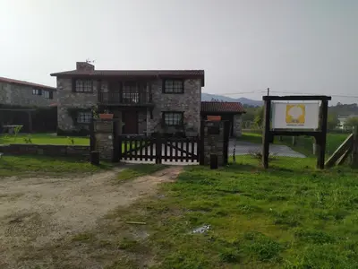 an old house with a gate and a sign at Camiño da Vieira in Padrón
