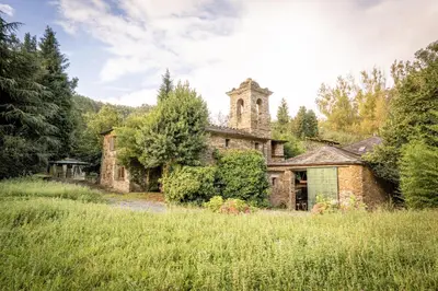an old stone building with a tower in a field at Villa en Asturias con cine, Piscina, BBQ, Juegos, 14 Pax in Cobre