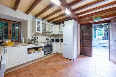 a kitchen with white cabinets and a white refrigerator at Villa en Asturias con cine, Piscina, BBQ, Juegos, 14 Pax in Cobre