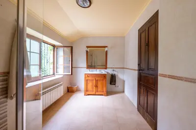 a bathroom with a sink and a wooden door at Villa en Asturias con cine, Piscina, BBQ, Juegos, 14 Pax in Cobre