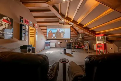 a living room with a couch and a large screen at Villa en Asturias con cine, Piscina, BBQ, Juegos, 14 Pax in Cobre