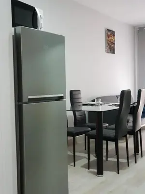 a dining room with a table and a refrigerator at A casa de Mateo in Ribadavia