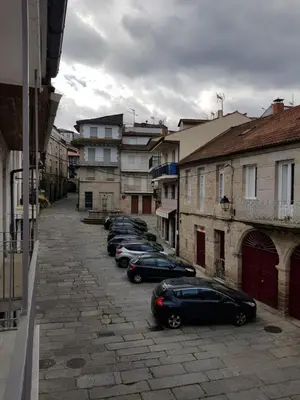 a row of cars parked in a street with buildings at A casa de Mateo in Ribadavia