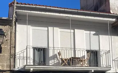 a dog sitting on a balcony of a building at A casa de Mateo in Ribadavia