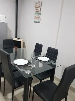 a dining room with a glass table and black chairs at A casa de Mateo in Ribadavia