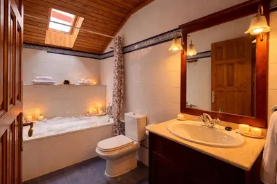 a bathroom with a toilet and a tub and a sink at Apartamentos rurales La Pornacal I y La Pornacal II in Villar de Vildas