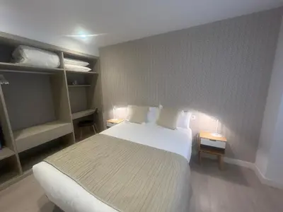 a bedroom with a large bed and shelves at CONCHEIROS 5 APARTAMENTOS TURISTICOS in Santiago de Compostela