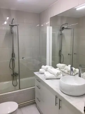 a white bathroom with a sink and a shower at Hostal Restaurante Alarico in Allariz