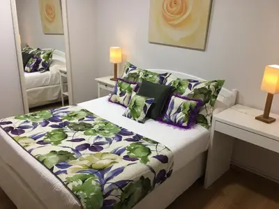 a bedroom with a bed with a purple and green comforter at Hostal Restaurante Alarico in Allariz