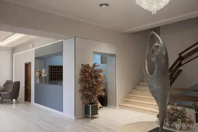 a living room with a staircase and a statue at Hotel San Rosendo in Ourense