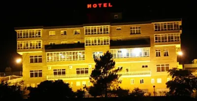a hotel building at night with a hotel sign on it at Hotel San Rosendo in Ourense