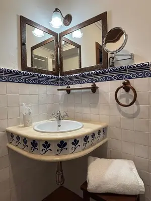 a bathroom with a sink and a mirror at As Tapias Apartamentos in Tapia de Casariego