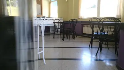a table and chairs in a room with a table and windows at Casa Poy in Becerreá