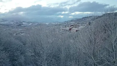 a town on a snowy hill with trees and buildings at Casa Poy in Becerreá