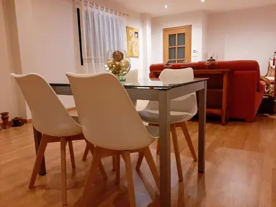 a dining room with a table and white chairs at Casa Galipendre in A Estrada