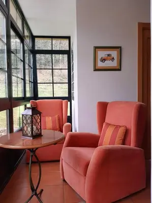 a living room with a red couch and a table at Casa Galipendre in A Estrada