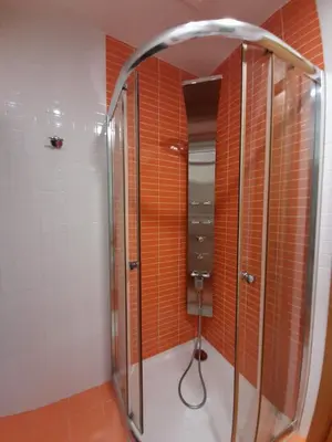 a shower in a bathroom with orange tiles at Casa Galipendre in A Estrada