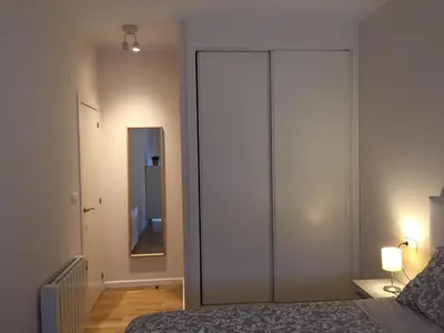 a bedroom with a large white closet and a mirror at AURINE in Foz