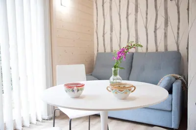 a white table with two vases and flowers on it at Cabanas da Ulla in Touro