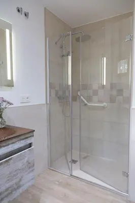 a shower with a glass door in a bathroom at Cabanas da Ulla in Touro