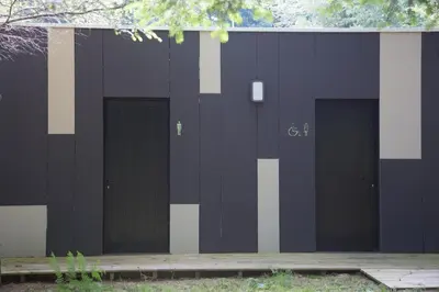 a black and white building with four garage doors at Cabanas da Ulla in Touro