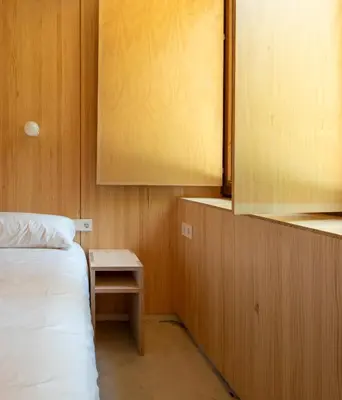 a small bedroom with a bed and a small table at Abeiro da loba in Madelos