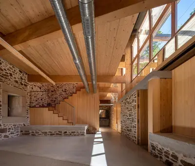 a building with wooden ceilings and a staircase at Abeiro da loba in Madelos