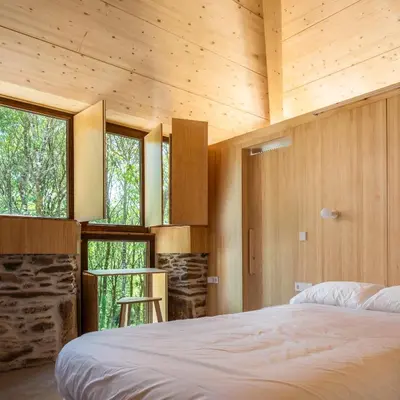 a bedroom in a house with a bed and windows at Abeiro da loba in Madelos