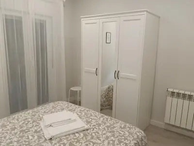 a bedroom with a bed and a white cabinet at PISO BENITO in Ourense