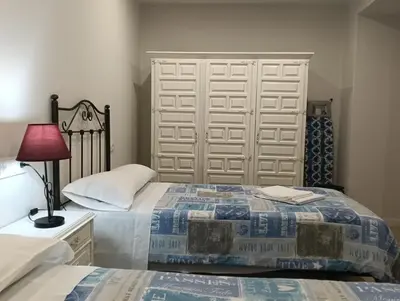a bedroom with two beds and a white closet at PISO BENITO in Ourense