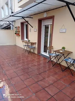 a patio with chairs and tables on a building at PISO BENITO in Ourense