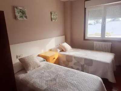 a small room with two beds and a window at Casa Manola in Teo
