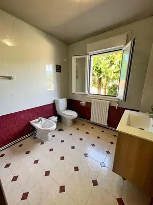 a bathroom with a toilet and a sink and a window at Casa Manola in Teo