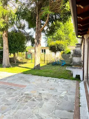 a stone walkway with a tree and a playground at Casa Manola in Teo