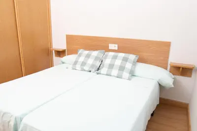 a bedroom with a white bed with two pillows at HOLIDAY HOMES Figueras AT in Castropol