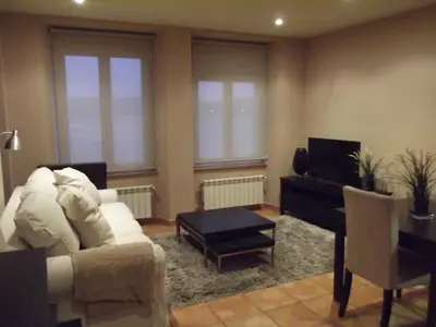 a living room with a white couch and a piano at HOLIDAY HOMES Figueras AT in Castropol