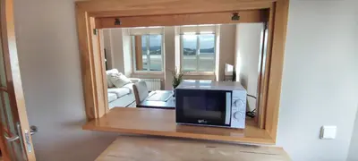 a microwave sitting on a table in a room at HOLIDAY HOMES Figueras AT in Castropol