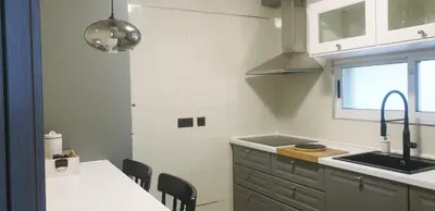a kitchen with a sink and a table with chairs at Apartamento tranquilo in Ponferrada