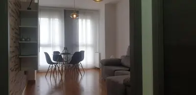 a living room with a table and chairs and a couch at Apartamento tranquilo in Ponferrada