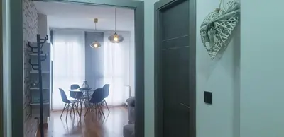 a living room with a table and chairs and a door at Apartamento tranquilo in Ponferrada