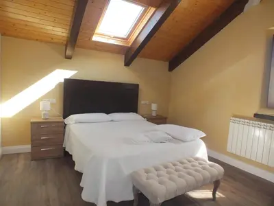 a bedroom with a large bed and a window at Apartamentos Puerta del Castro in Coaña