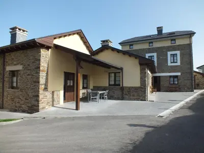 a large brick building with a table in front of it at Apartamentos Puerta del Castro in Coaña